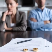 selective focus of couple sitting at table with divorce documents