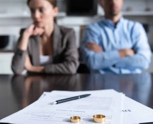 selective focus of couple sitting at table with divorce documents