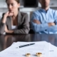 selective focus of couple sitting at table with divorce documents