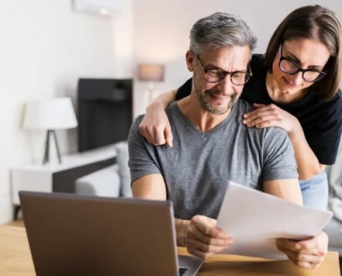 Twee mensen die leningen hergroeperen op een computer
