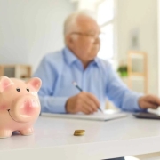 Oudere man op de computer bezig met hypotheek en financieren.
