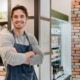 Zelfstandige ondernemer met gekruiste armen in zijn eigen winkel, symbool voor hypotheek hergroeperen als zelfstandige